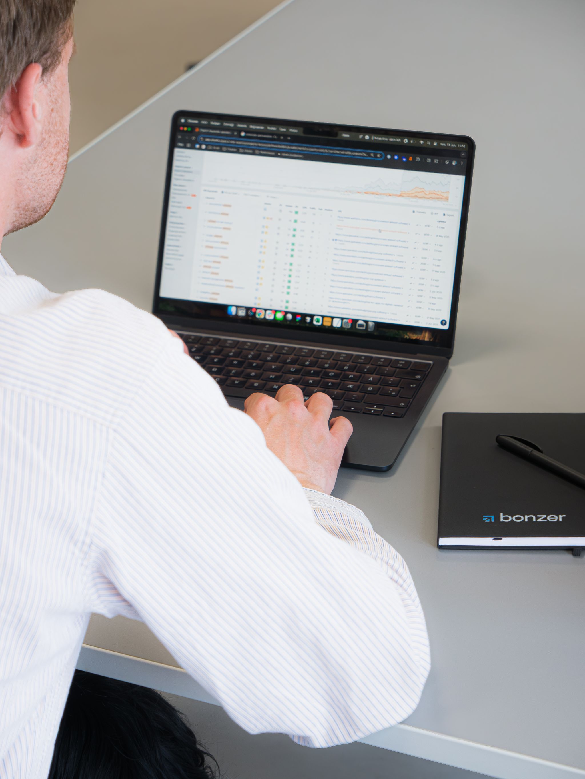 Hender på en laptop med et SEO-dashbord