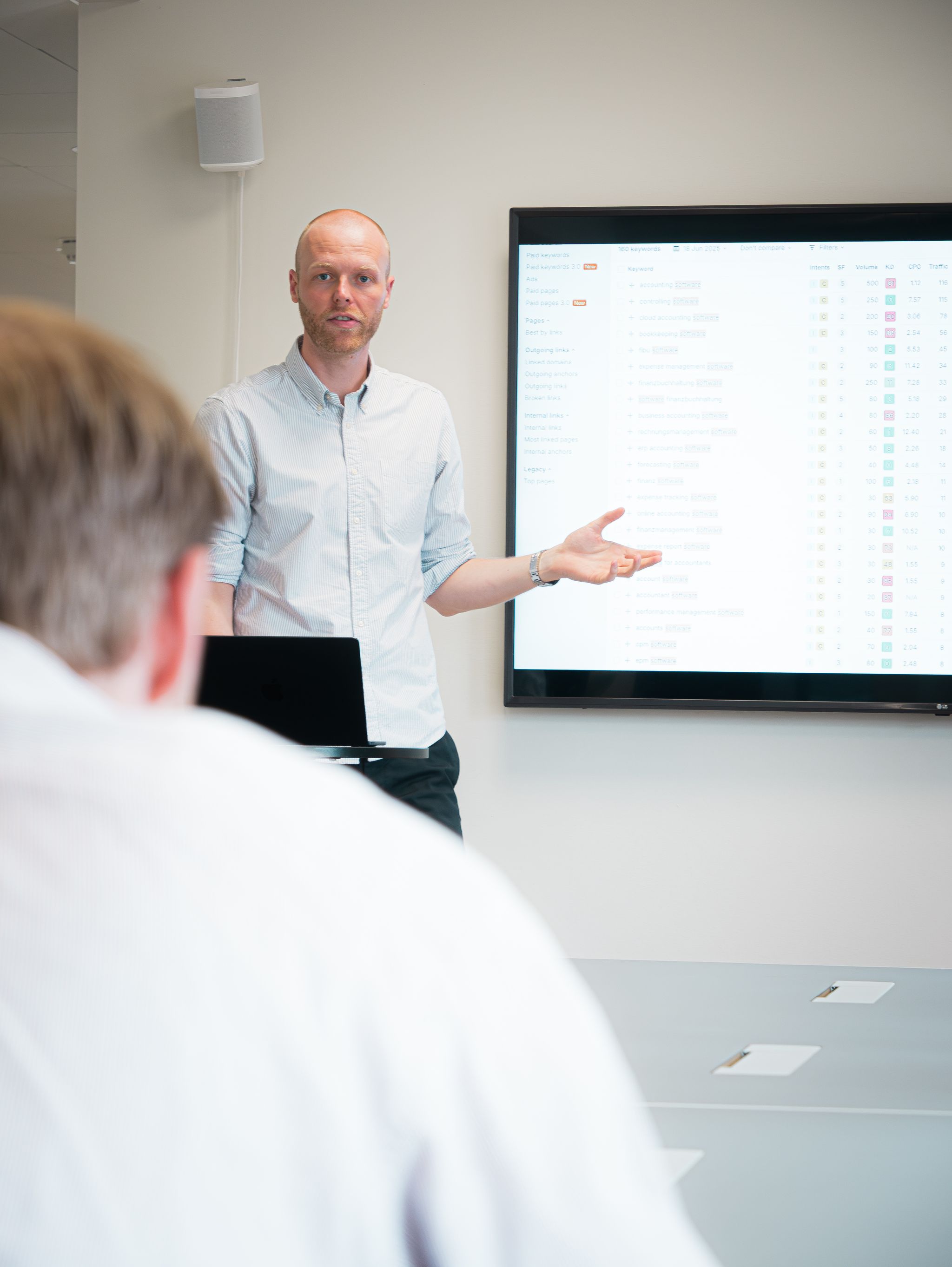 Bonzer specialist holder foredrag og peger på data og keywords på en storskærm